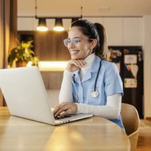 Nurse using laptop at home